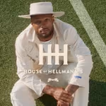 A man sat on the floor looking up wearing the new House of Hellmann’s denim collection.