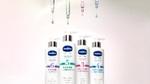 Four bottles of Vaseline Pro Derma skincare containing niacinamide. Bottles are white, with vials of serum are pictured above them.