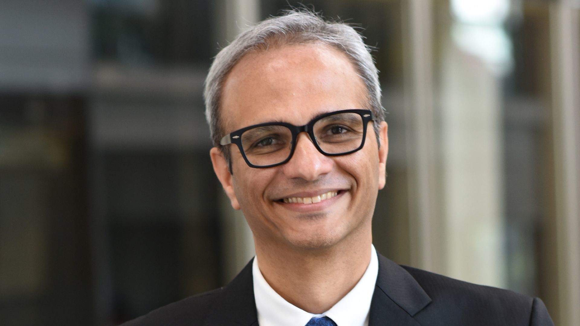 Profile picture of Srinivas Phatak wearing a white shirt, dark tie and suit jacket. He is wearing glasses.
