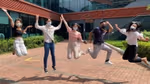 A group of people wearing masks jumping in the air in front of a Unilever office