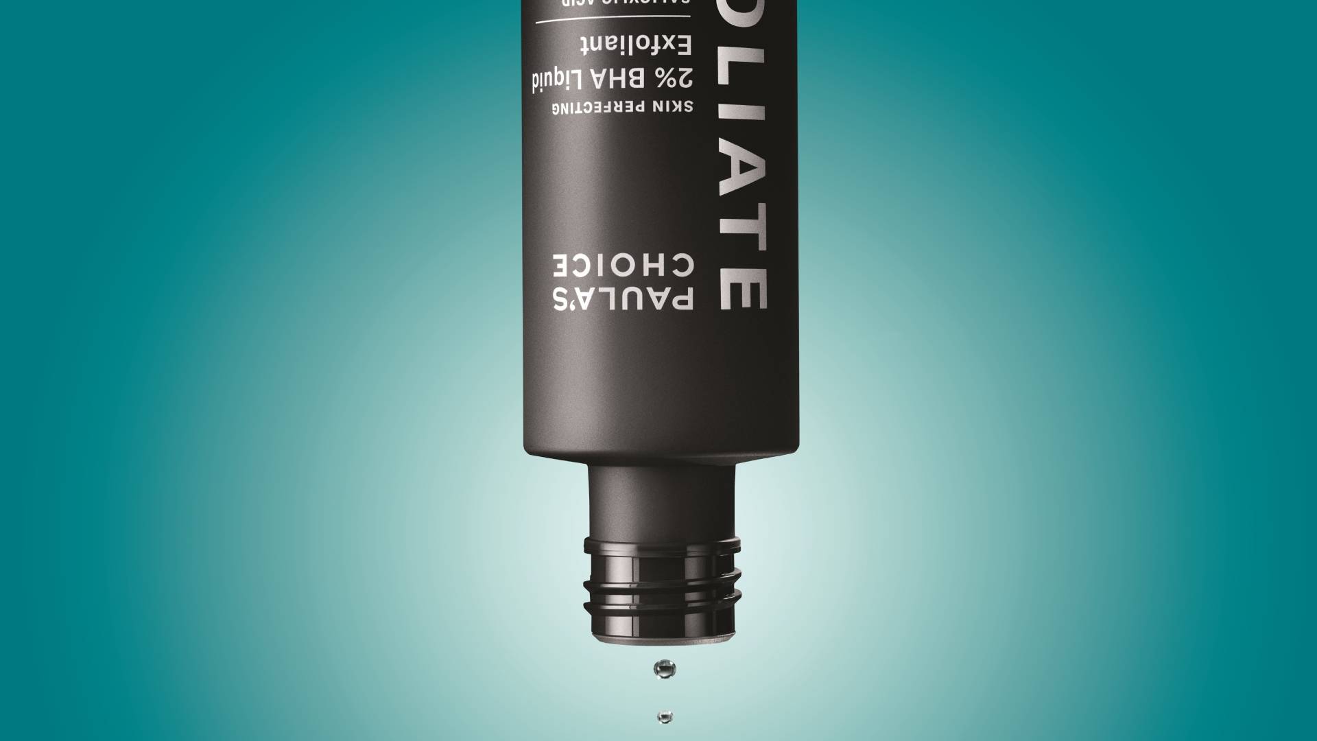 An upside-down black bottle of Paula’s Choice 2% BHA Liquid Exfoliant suspended against a teal gradient background, with several small droplets falling from the open nozzle. The minimalist composition highlights the product’s matte black packaging and dripping liquid.