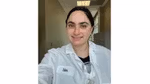 A photo of a scientist who worked on the Vaseline Verified campaign. A white woman with brown hair, in a lab coat.