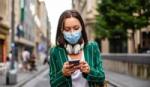 Woman walking in the city and checking her smartphone