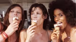 Three women smiling into the camera eating Cornetto ice creams on a sunny day