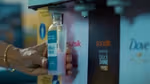 A refill station with Unilever brands including Sunsilk and Dove. The image shows a bottle being filled with pink Sunsilk product and a person holding the bottle.