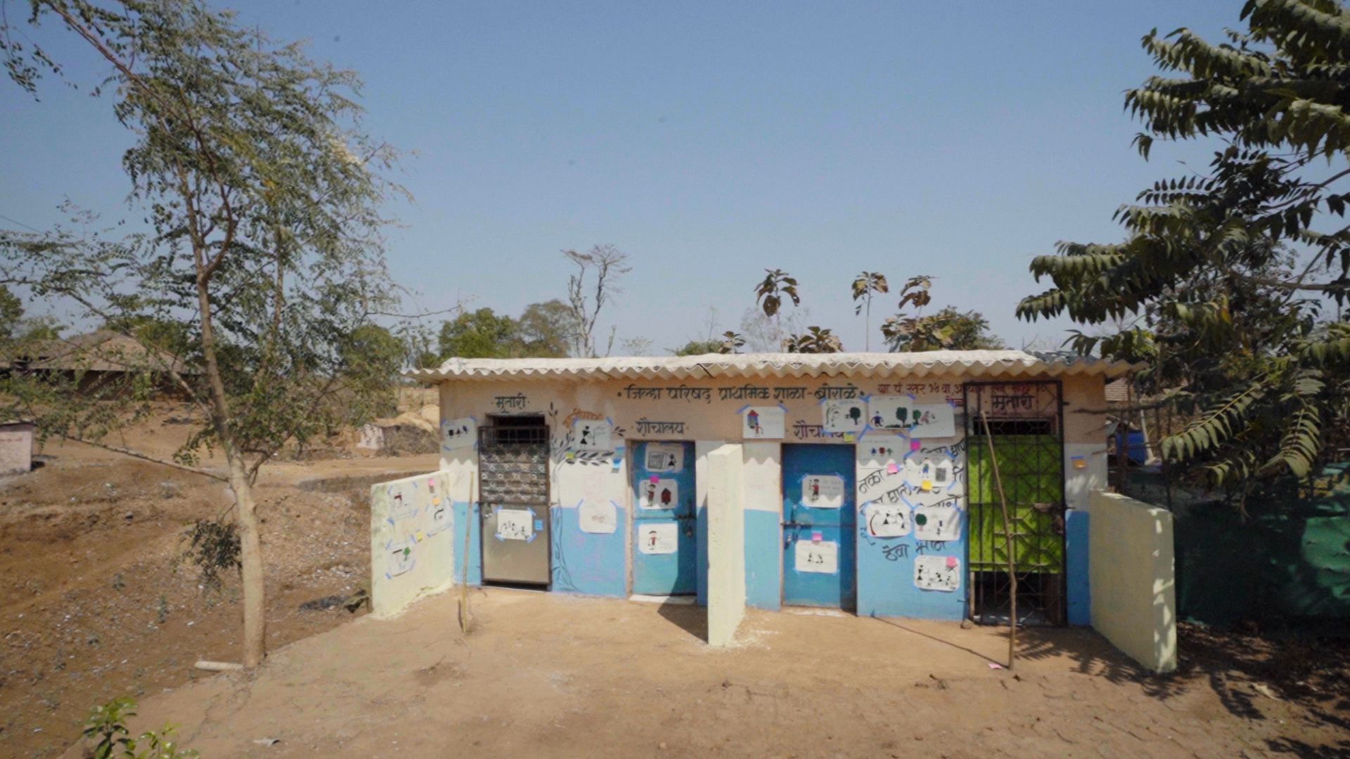 A block of toilets colourfully decorated in blue and cream.