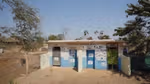 A block of toilets colourfully decorated in blue and cream.