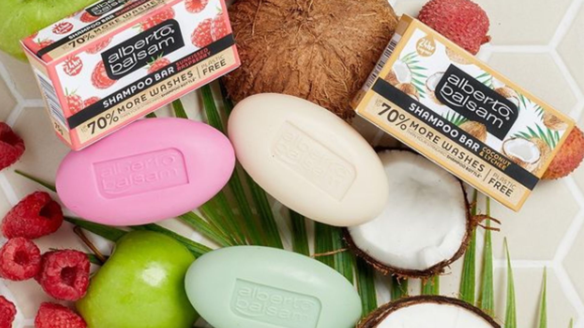 Image shows Alberto Balsam Shampoo Bars surrounded by opened coconuts, apples and raspberries