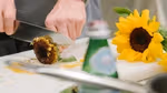 Close-up of a sunflower being sliced before being cooked.