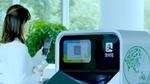 Woman holding plastic bottle ready to scan its QR code into an AI-enabled recycling and sorting machine