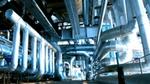 A modern industrial facility with large, interconnected metal pipes and ducts.