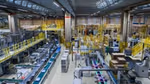 Image of a factory production line, with products on conveyer belts.