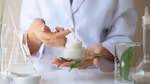 A person holding a jar of cream
