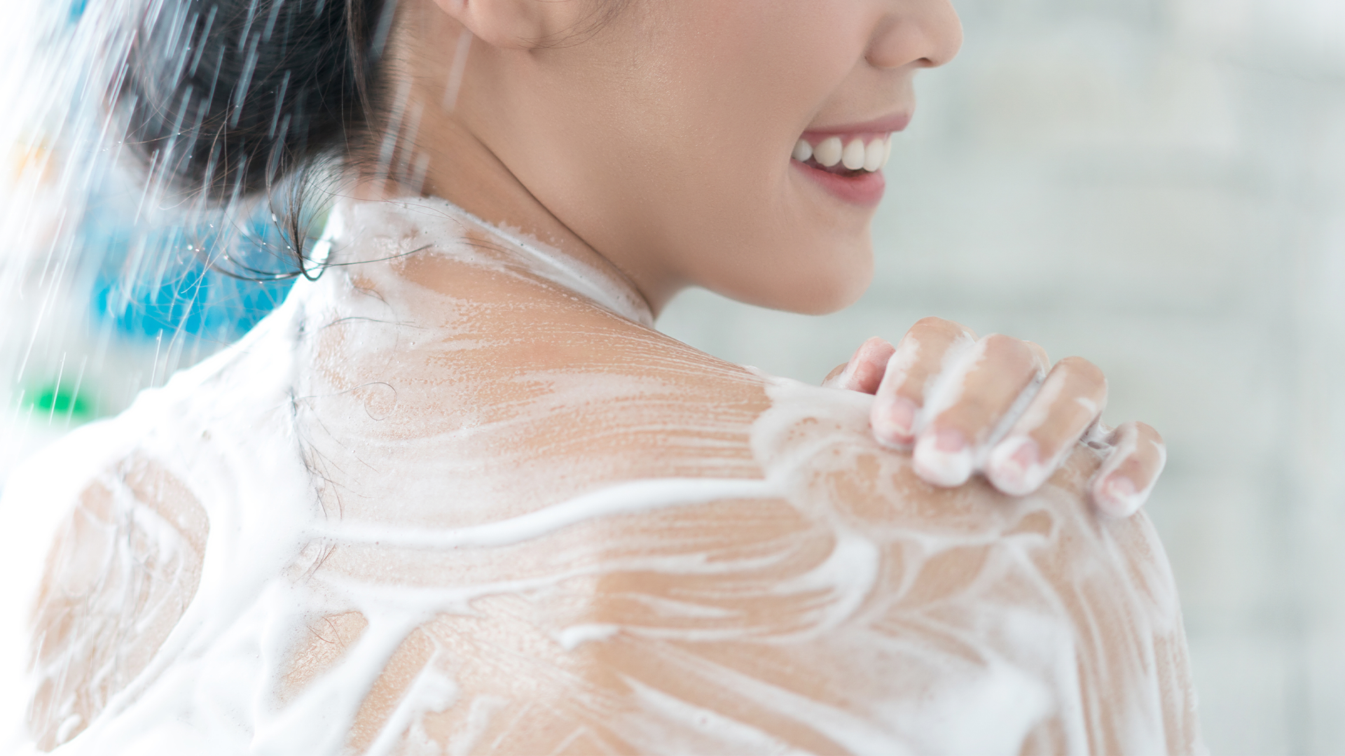 A woman smiles as she washes with Lifebuoy’s Skin Solutions shower gel that combines cleansing with beauty benefits.