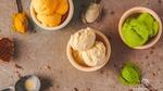 Three small bowls of ice cream on a table.