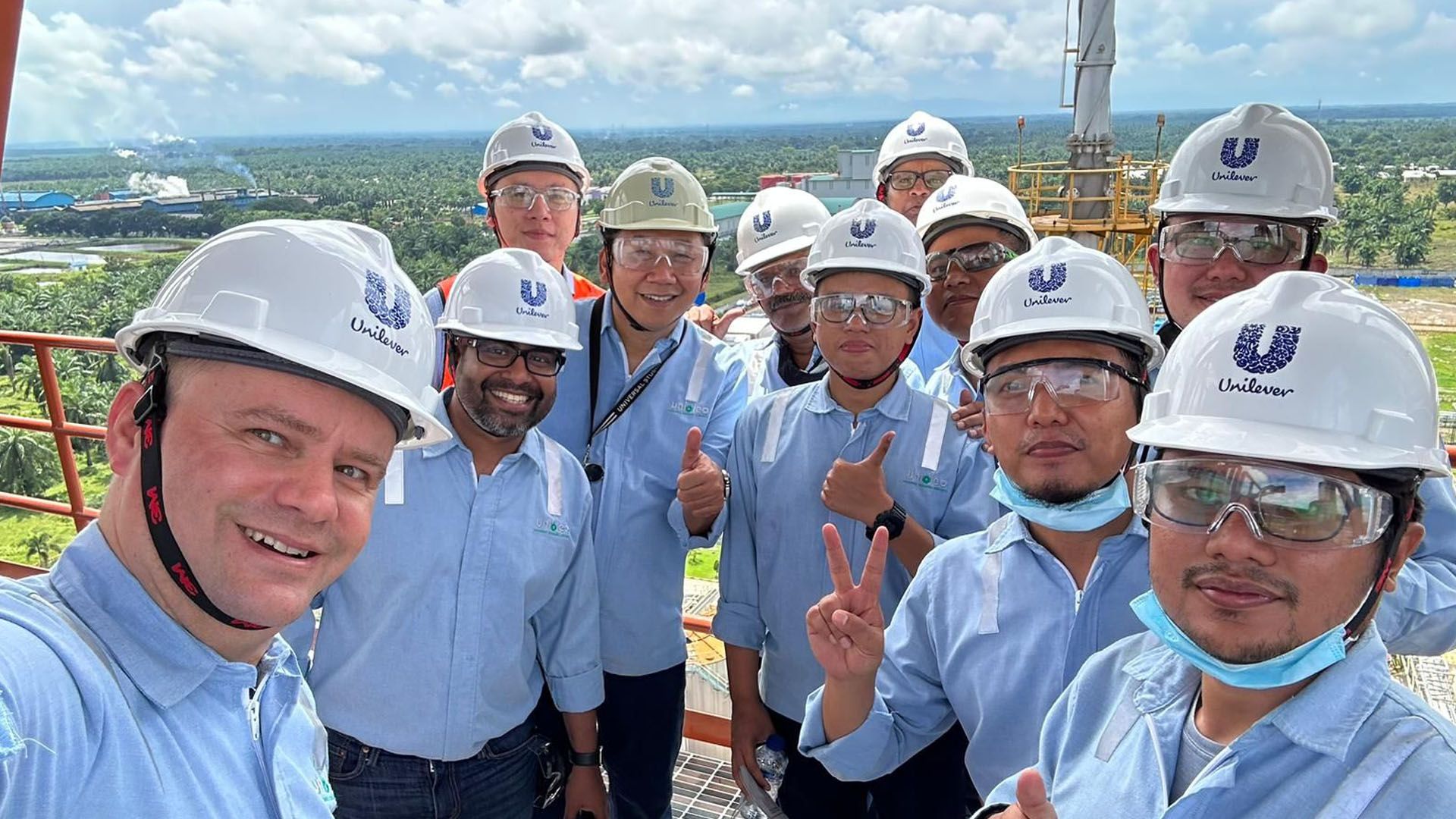Chief Procurement Officer Willem Uijen with a team of people wearing hard hats, on a high-rise platform at a factory.