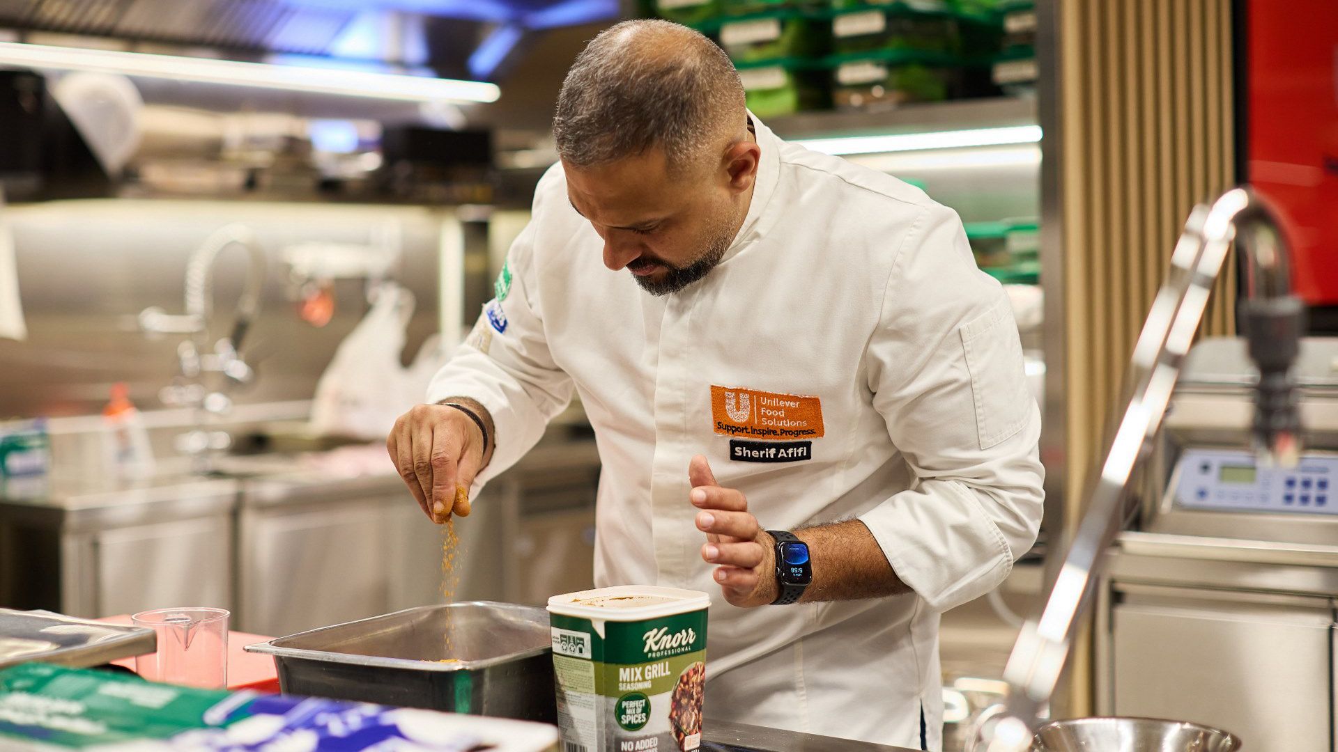 A chef from Unilever Food Solutions sprinkling some Knorr product into a tray