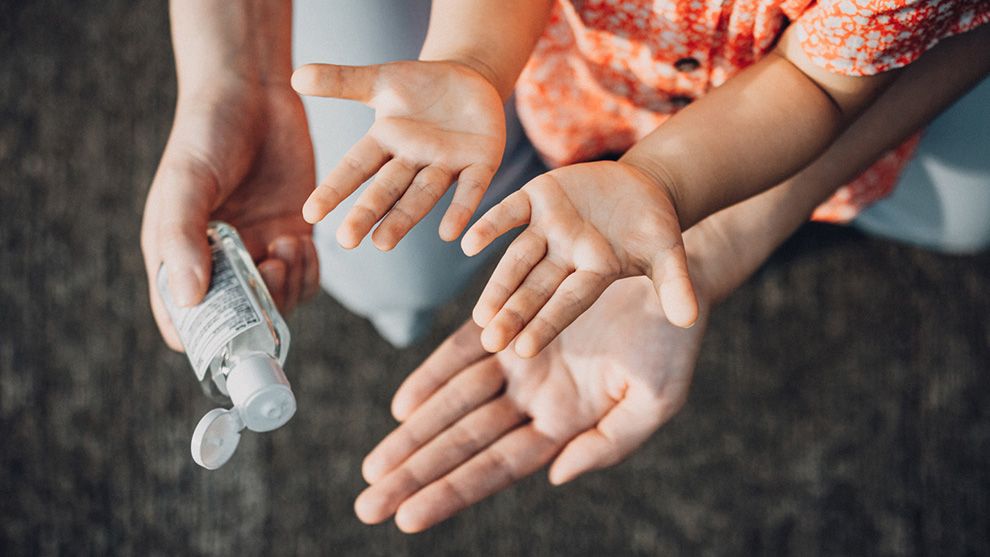 Hands applying hand sanitiser gel