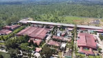 An aerial photo of Unilever’s Tinsukia factory in India, recognised by the World Economic Forum’s Lighthouse Network. The large rural building has a sustainable water collection pool and solar panels.
