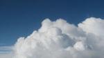 A photo of a blue sky with large white clouds in the foreground