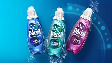 Three Persil Wonder Wash bottles in blue, teal, and purple displayed against a blue background with water splash effects.
