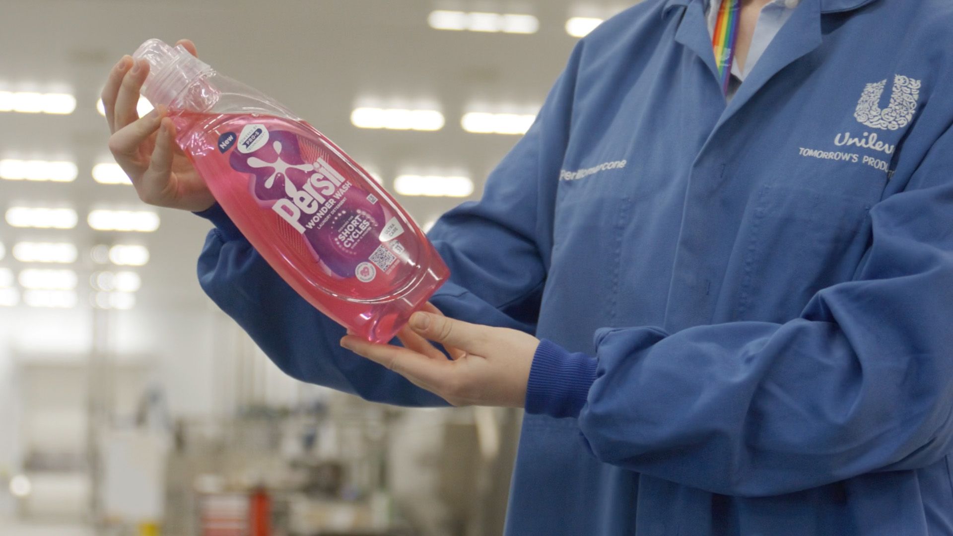 Unilever scientist inspecting Wonder Wash bottle made from recycled plastic