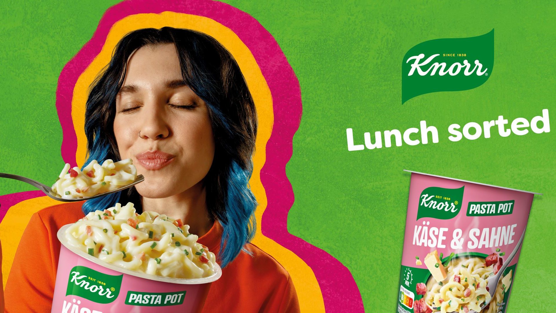 A woman with dark hair closes her eyes as she lifts a fork loaded with Knorr Mini meal Carbonara Pasta.