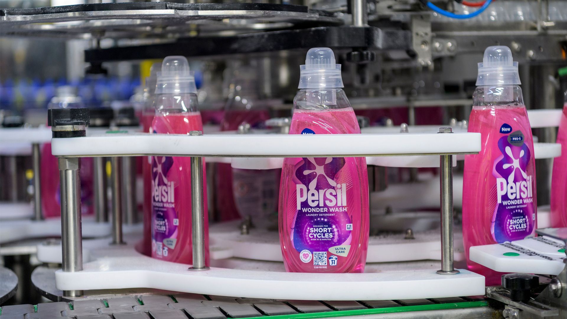 Bottles of Persil Wonder Wash along a factory line.