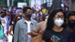 Man in a crowd wearing a mask
