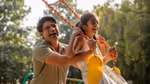 Two people on a swing in a park setting