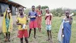 Six smiling children in rural South Sudan showing off the Unilever soap bars they have been given to wash their hands