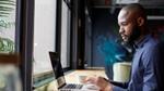 A man working on a laptop by a window