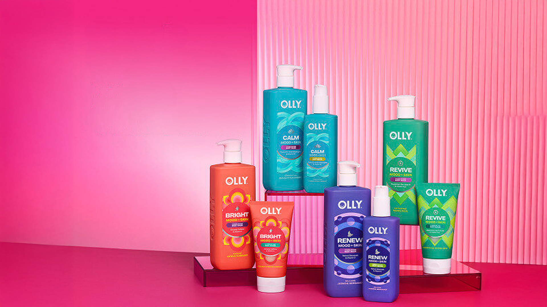 A display of eight OLLY mood-boosting body washes on a pink background.