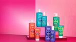 A display of eight OLLY mood-boosting body washes on a pink background.