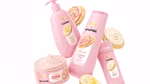 Products from the Dove Crumbl collaboration including Confetti Cake body wash in a pink bottle. Crumbl cookies in background.