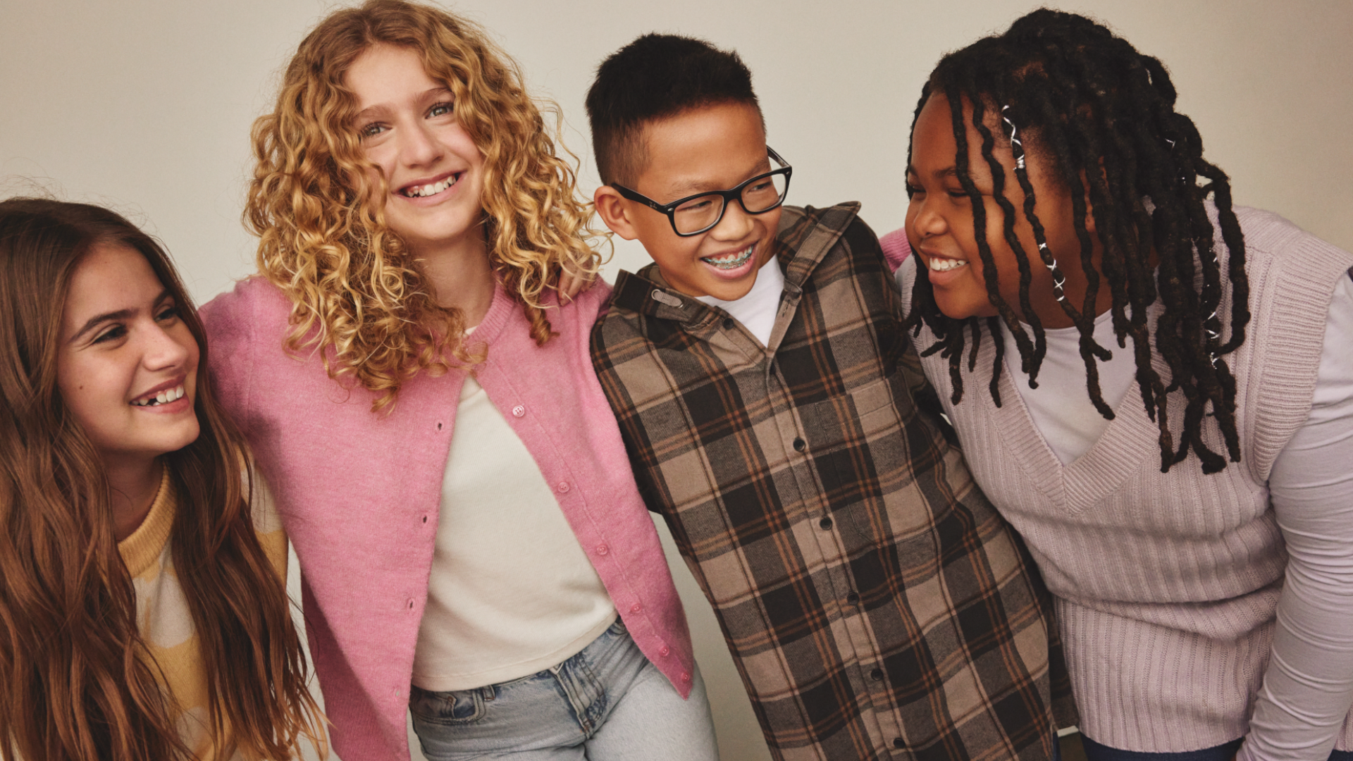 A pic from a Dove campaign of four young teenagers smiling and laughing together. There are three girls and one boy.