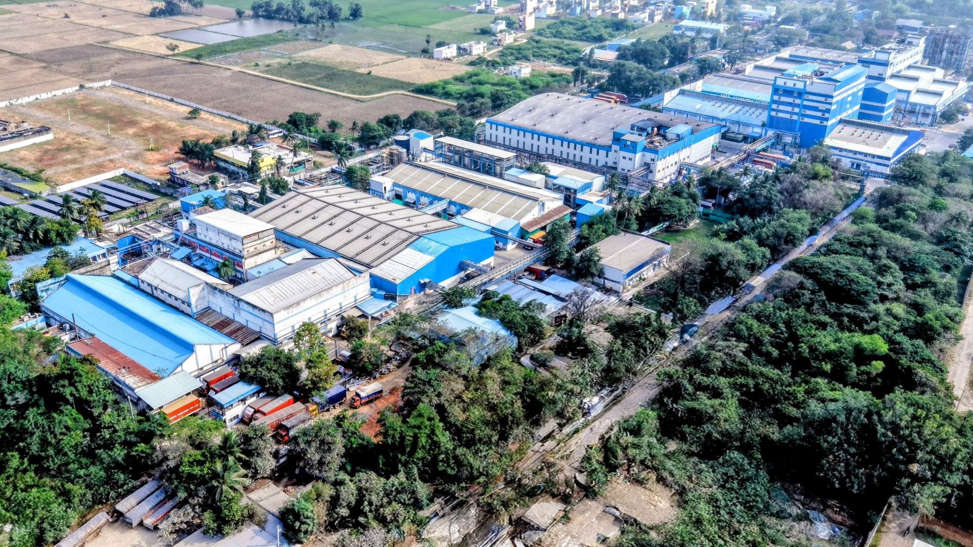 An aerial view of Unilever’s Home Care factory in Pondicherry, India, a network of large industrial buildings painted blue and white.