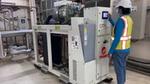 A factory worker programmes a heat pump in our Personal Care factory in Dubai, India.