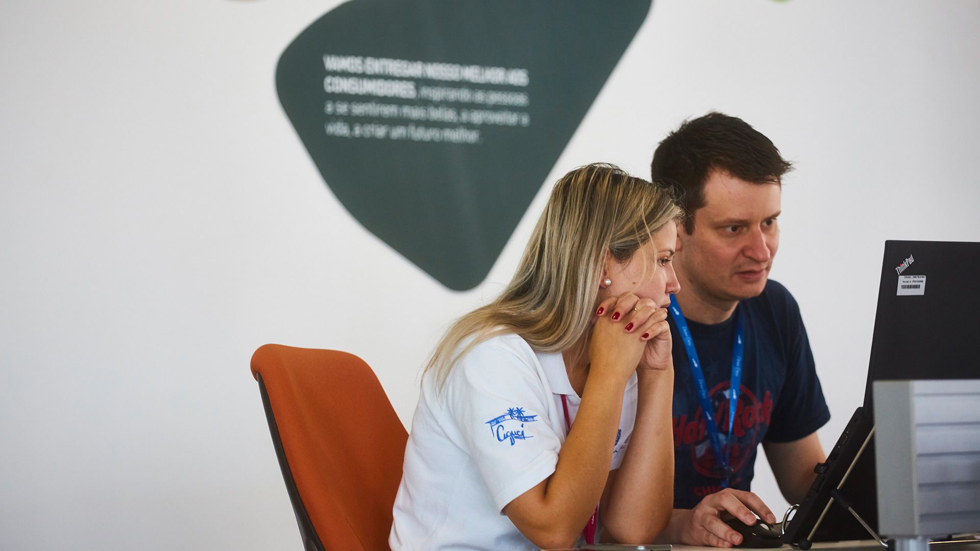 Two employees studying their computer screen at our factory in Brazil