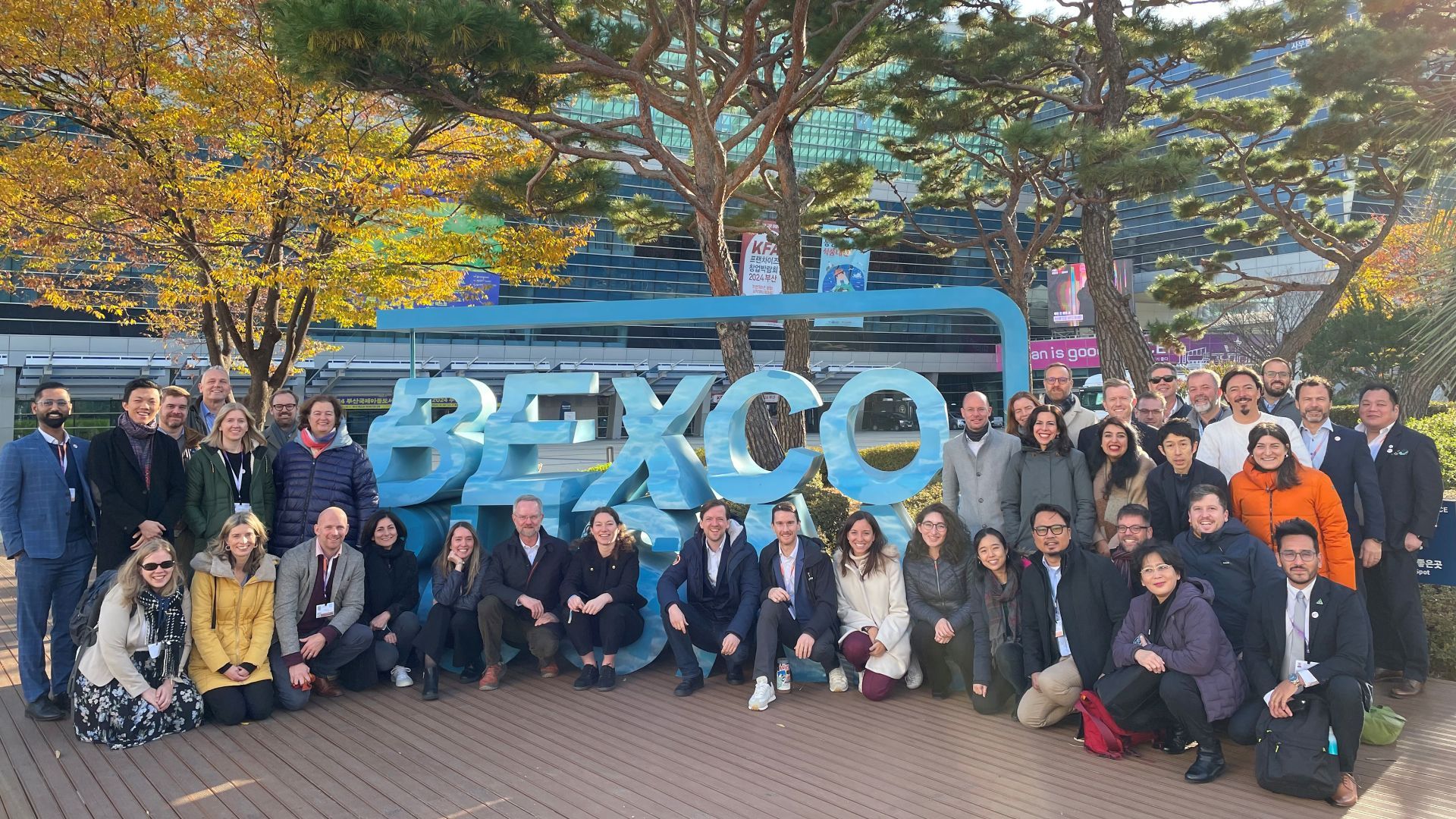 Attendees at the negotiations on a UN treaty to end plastic pollution, posing for a photograph outside the meeting hall.