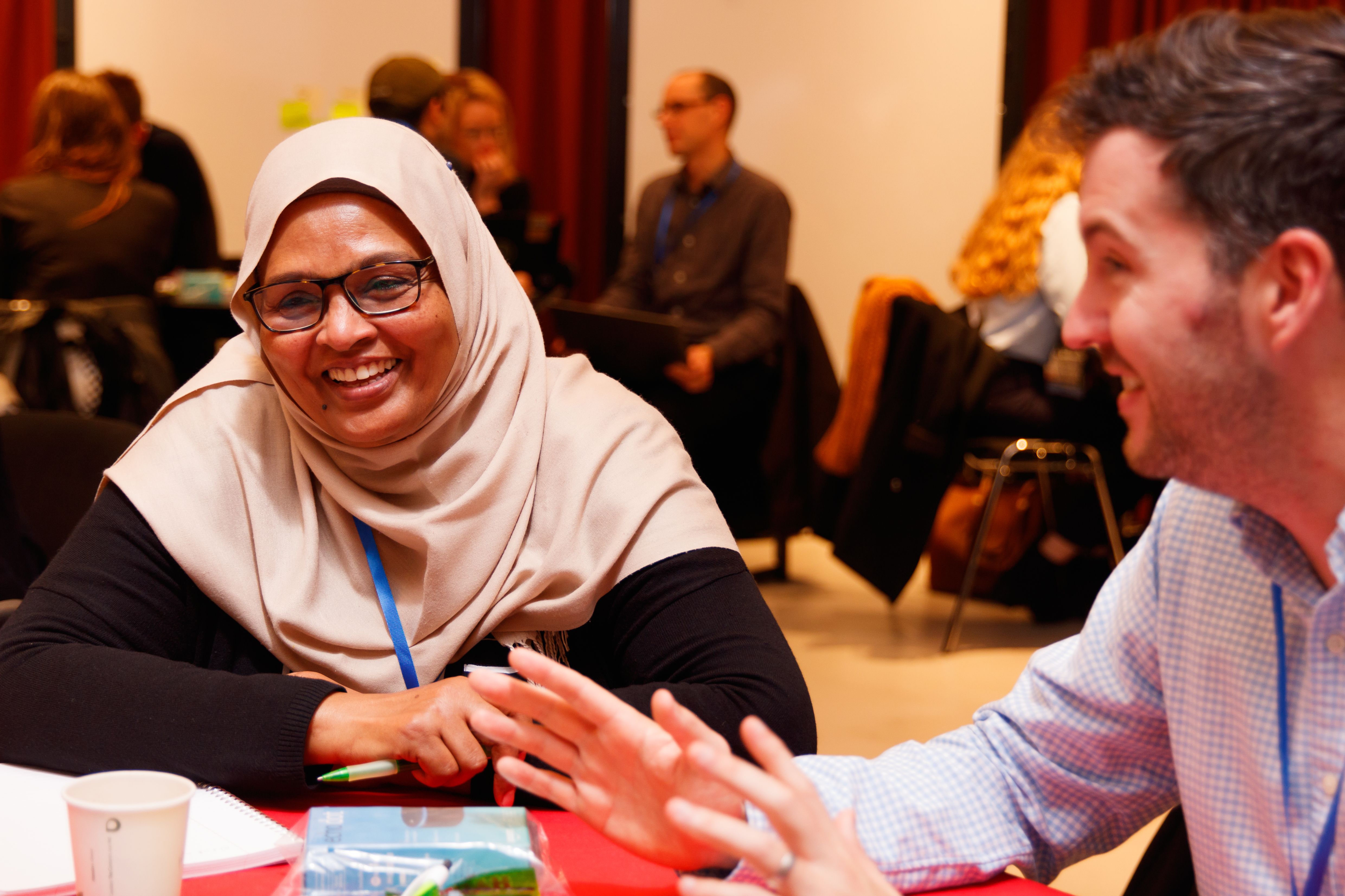 Woman and man smile and talk at a conference