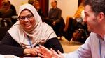 Woman and man smile and talk at a conference