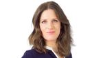 A photo of Dr Victoria Fraser, R&D Director for Dove. She is a white woman with brown hair and blue eyes, smiling at the camera.