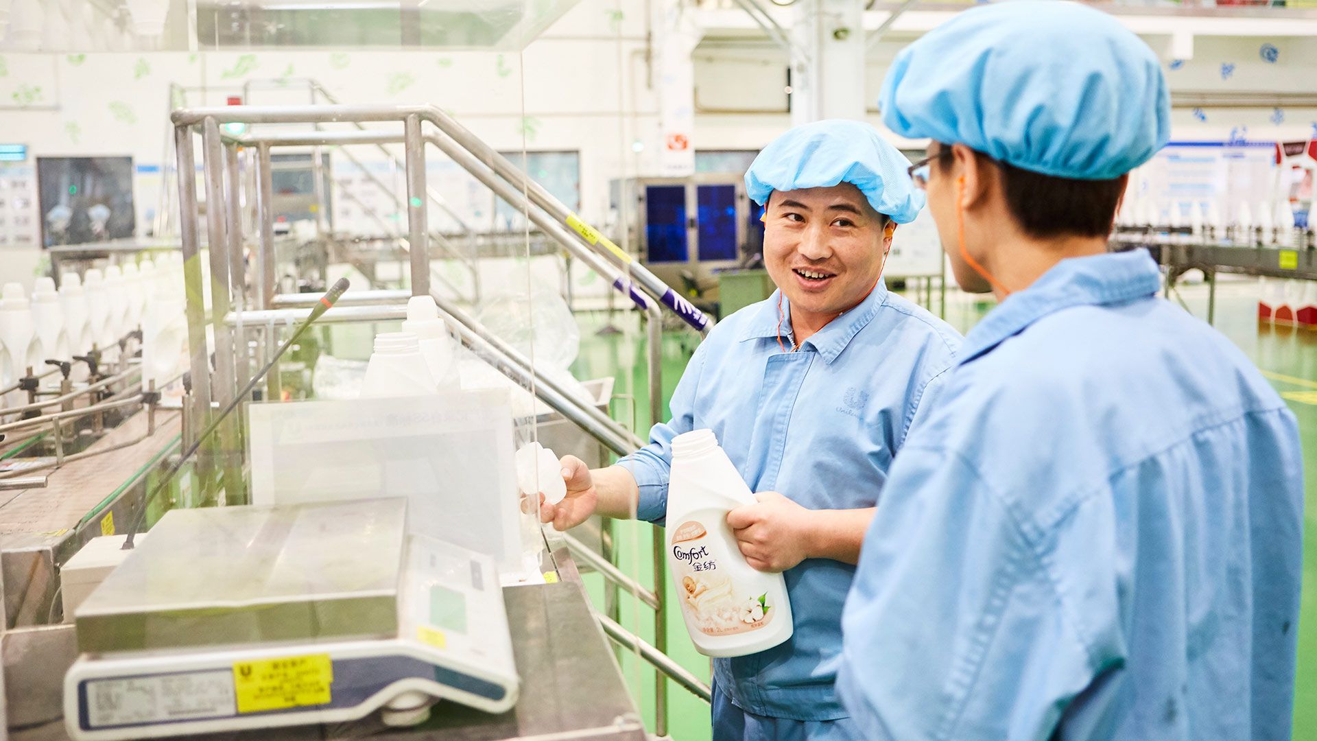 Two men in blue overalls talking to each other at our factory in China