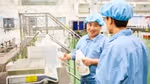 Two men in blue overalls talking to each other at our factory in China