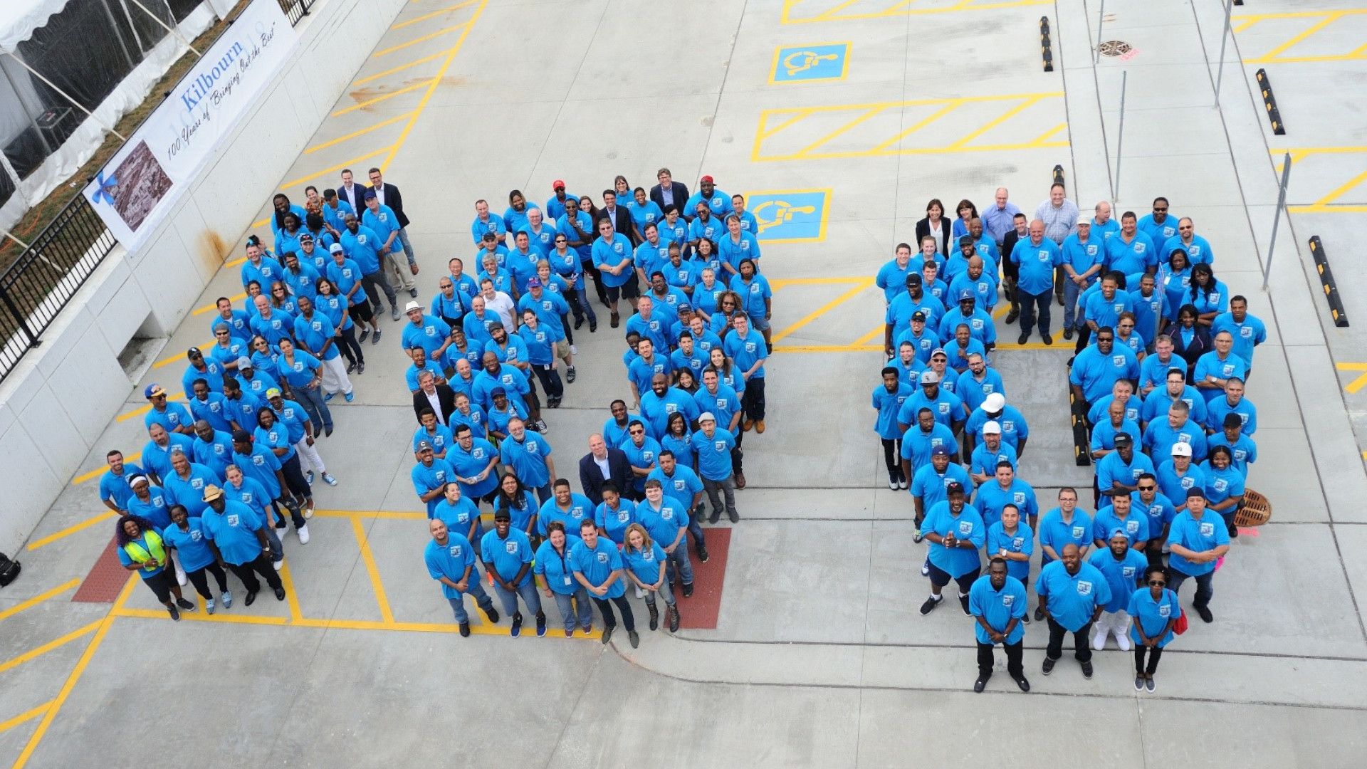 The factory team at Kilbourn, US, line up to form the number 100 as part of the centenary celebrations
