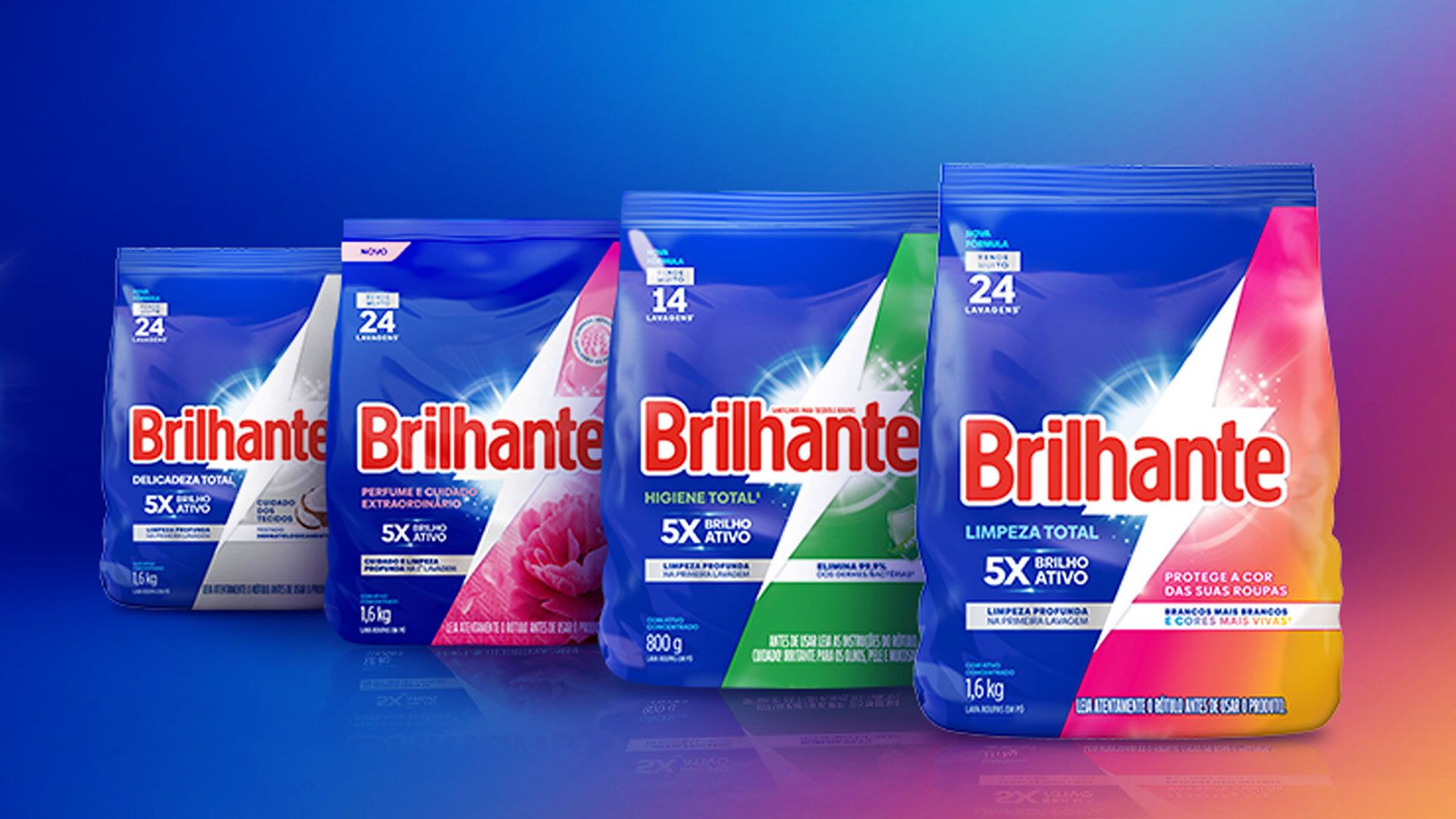 Four colourful Brilhante laundry detergent packs arranged side by side against a blue gradient background. Each pack features bold red Brilhante branding and different colour accents to represent various product variants. The packs display washing related claims such as number of washes and cleaning performance. The bright lighting and clean layout highlight each product clearly.