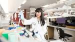 A woman in a white lab coat working at one of Geno’s biotech labs