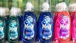 Persil Wonder Wash plastic laundry detergent bottles lined up in a row. There are three colours of detergent – green, blue and pink. The packaging labels explain that the product is designed for short cycles.